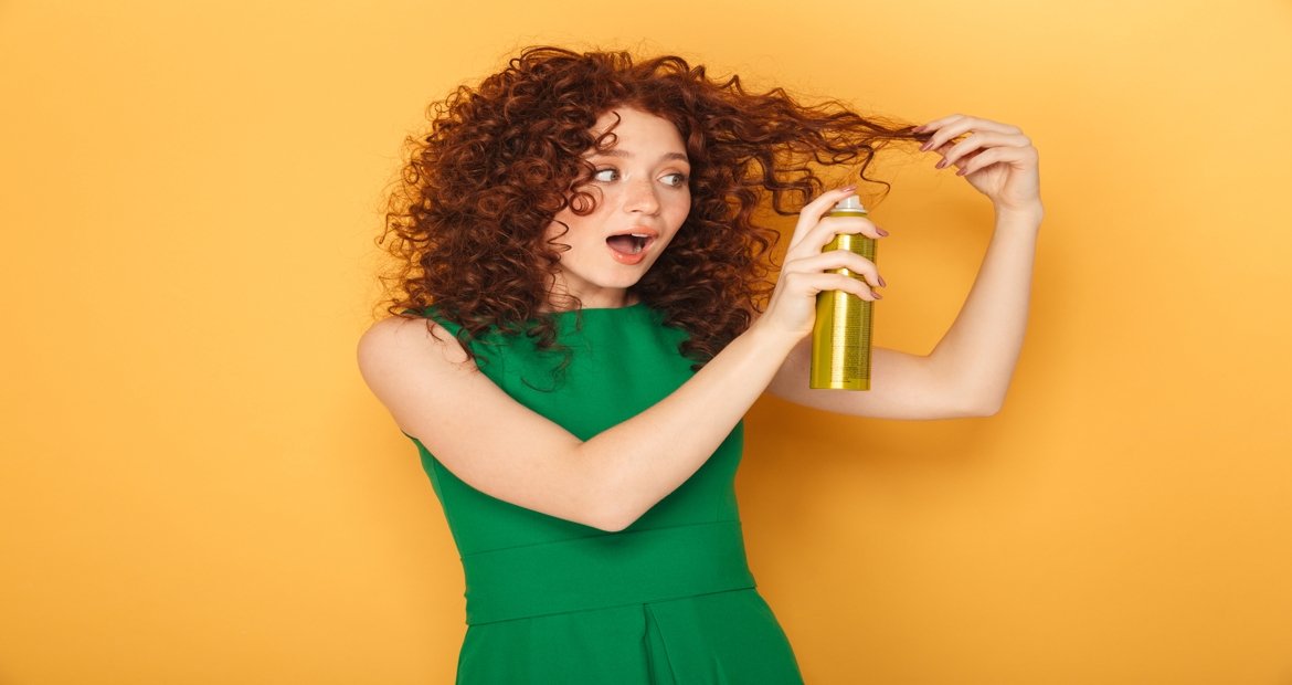 Mulher passando spray no cabelo